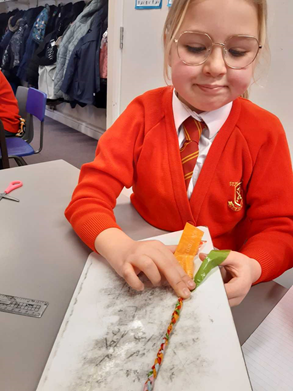 Year 4 child making a friendship bracelet.