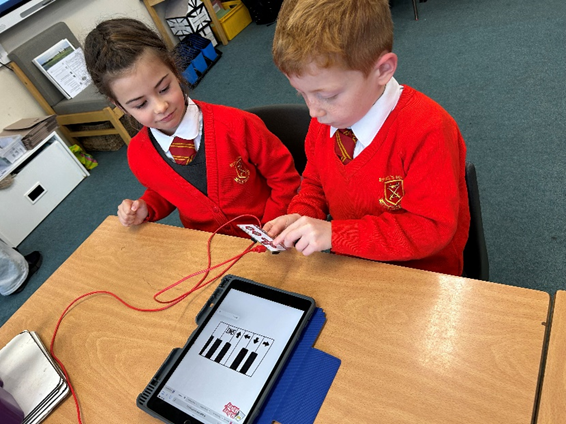 Two children experimenting with musical notes