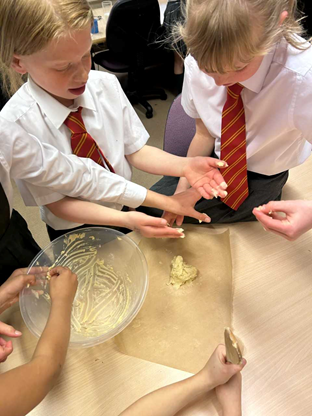Children putting biscuit dough on baking paper
