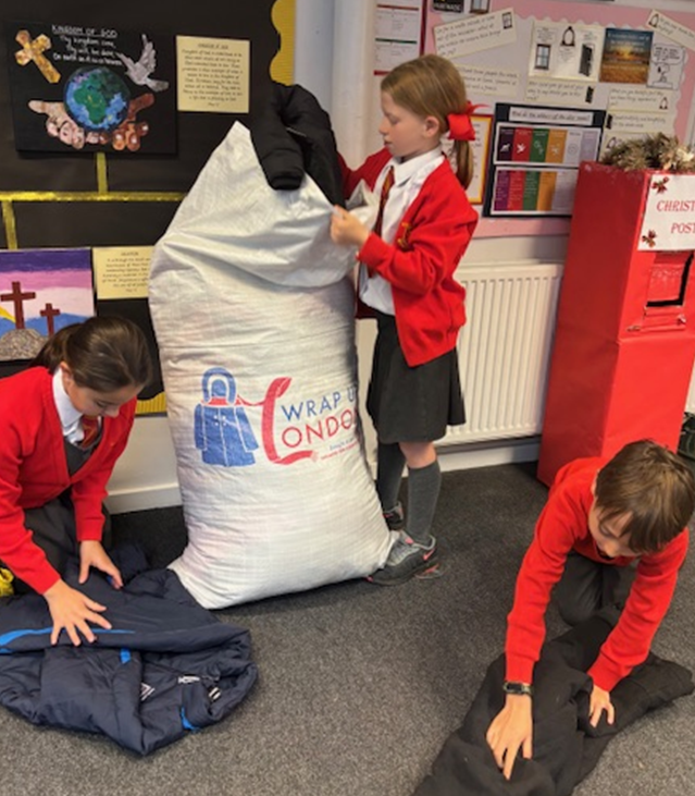 Children packing up coats for Wrap Up London Campaign