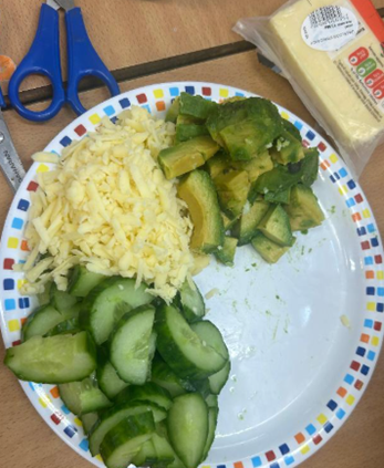 Plate of grated cheese, sliced avocados and cucumbers