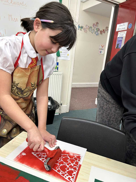 A girl with dark hair makes a flag with a red heart print on it.