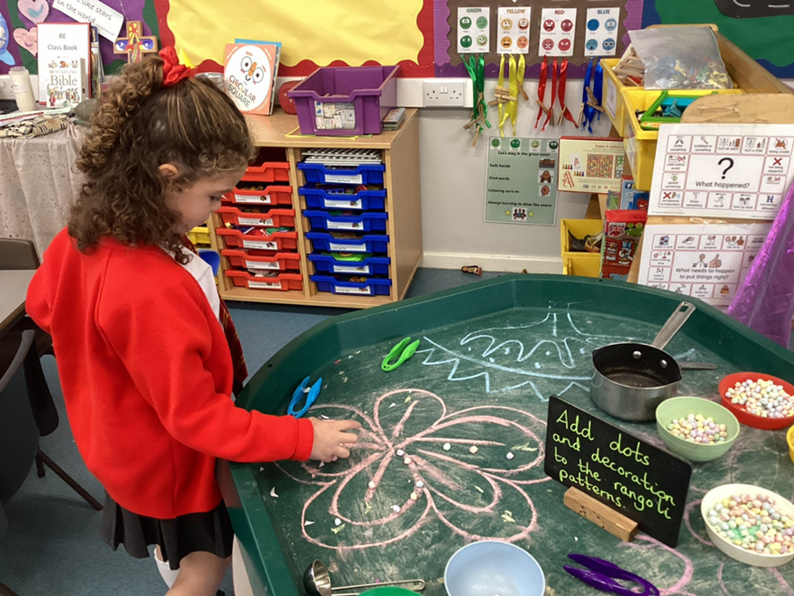 Developing our fine motor skills by using tweezers to create Rangoli patterns.