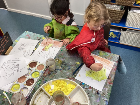 Using tissue paper, paint, glitter and glue to decorate pictures of St. Paul