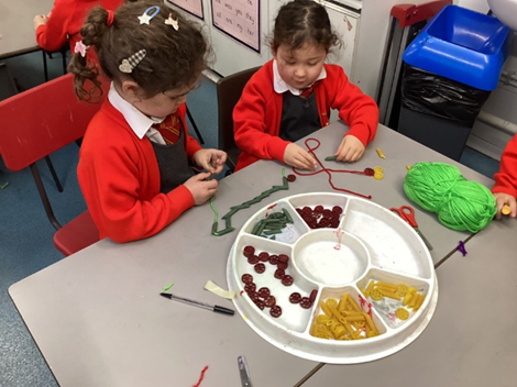 Threading pasta to make our own jewellery 