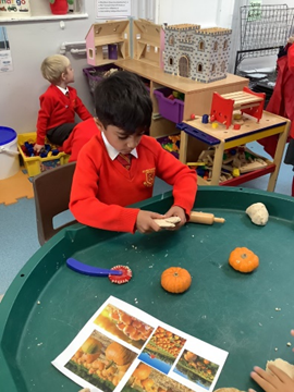 Reception child taking part in Harvest Festival activity with play dough