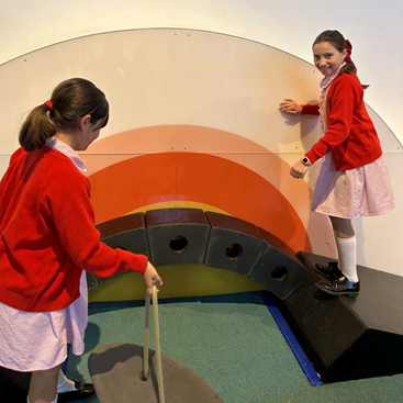 Two girls building a bridge and walking across it 