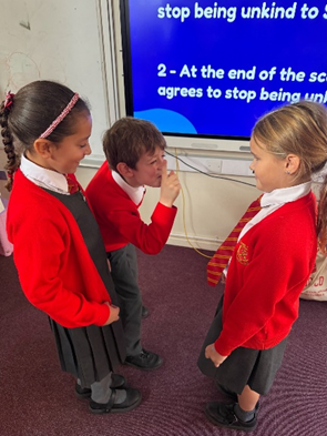 Three children acting out an Anti-bullying scenario showing everyone how they could respond to witnessing bullying.