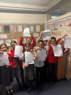 Children gathered around each other holding up their Compliment Carousel sheets.