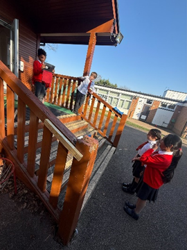 Children standing on steps reporting on the process of digestion whilst another child records them with an iPad.  