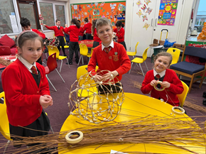 Children building Willow 3D sculptures with willow and tissue paper.