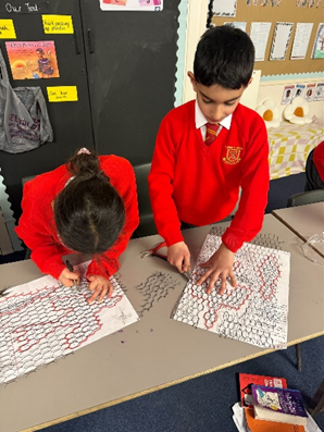 Two children concentrating on cutting out their wire mesh template. 
