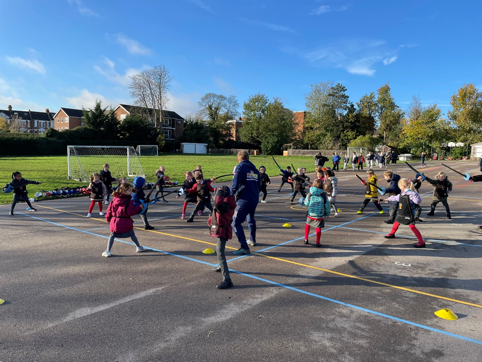 Children learning how to fence on the school playground